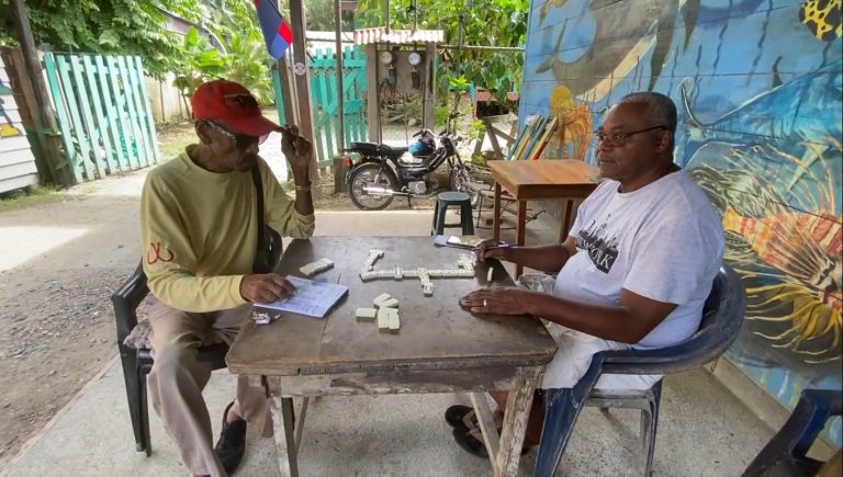 Dos adultos mayores, Antonio Taylor y Edgar Campbell, juegan juntos un juego de mesa,