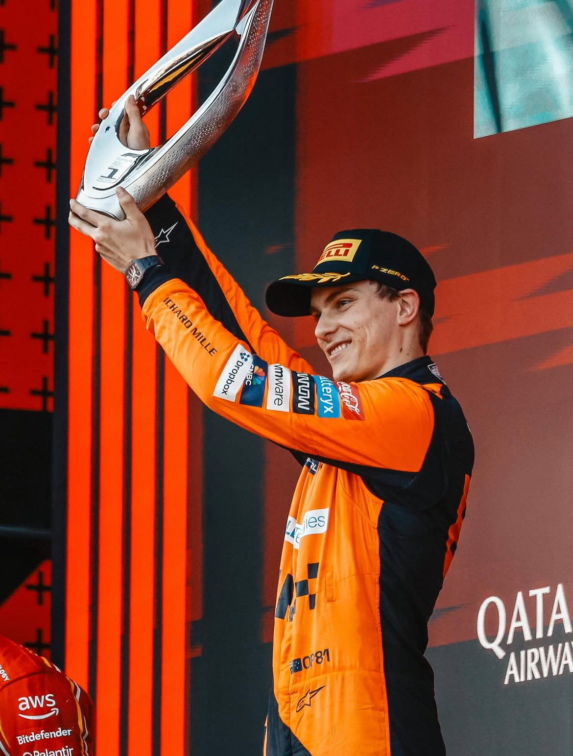 Oscar Piastri celebrando victoria de McLaren con premio.